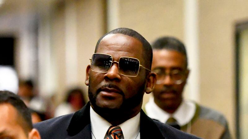 FILE - Musician R. Kelly, center, leaves the Daley Center after a hearing in his child support...