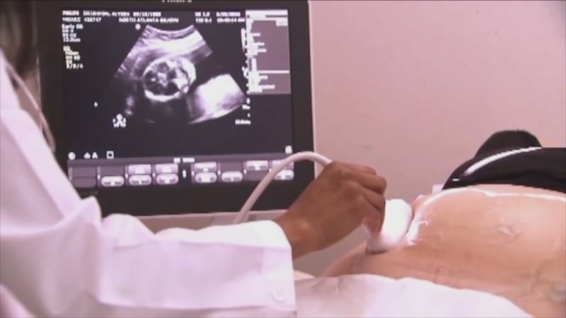 A healthcare professional performs an ultrasound scan.